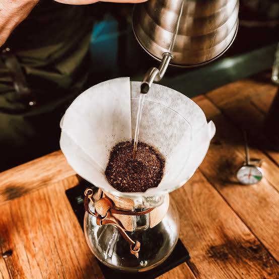 Preparo manual de café filtrado sobre uma mesa de madeira rústica