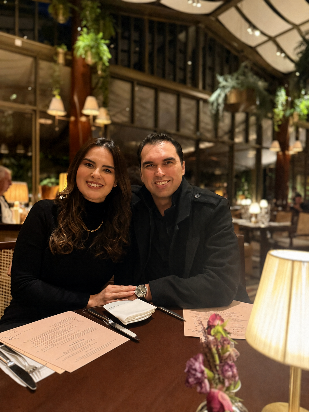 Marcos e Viviane em um jantar a dois, sorrindo à mesa